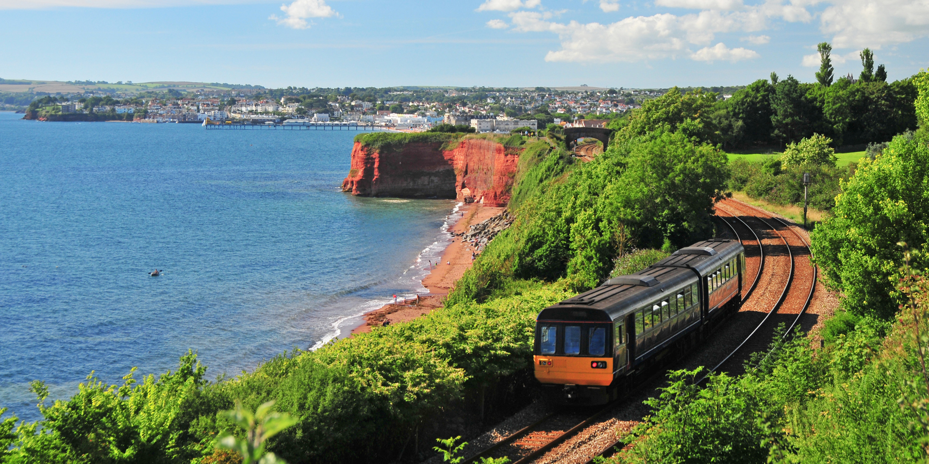 Torquay seafront with a train on the tracks at the bottom